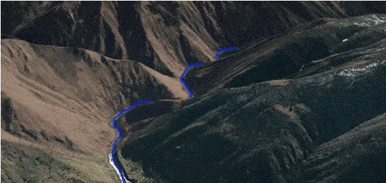 Aerial view of mountain with a blue line in the valley as the planned route for drone survey